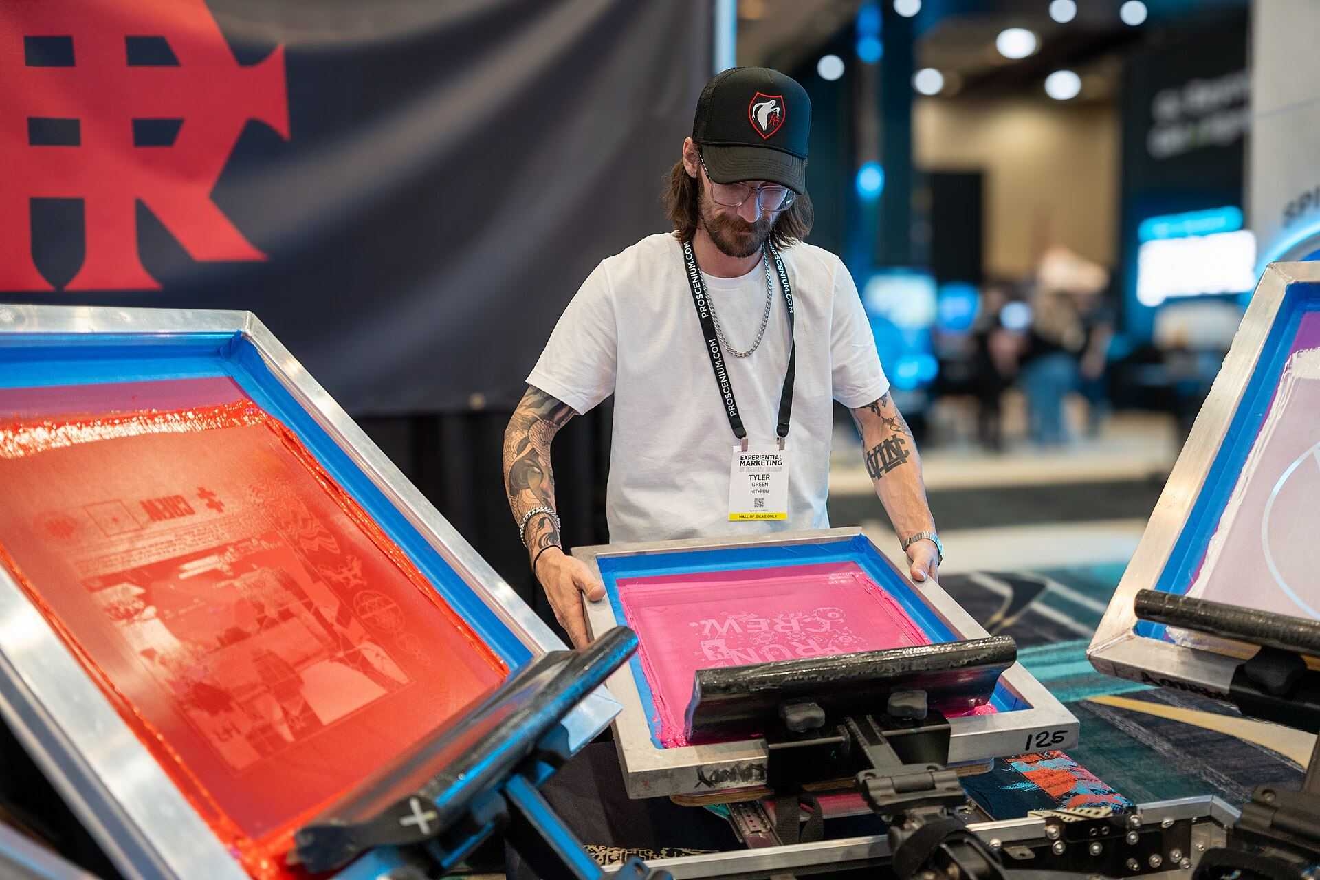 An artist screen-printing a design live for visitors at an event