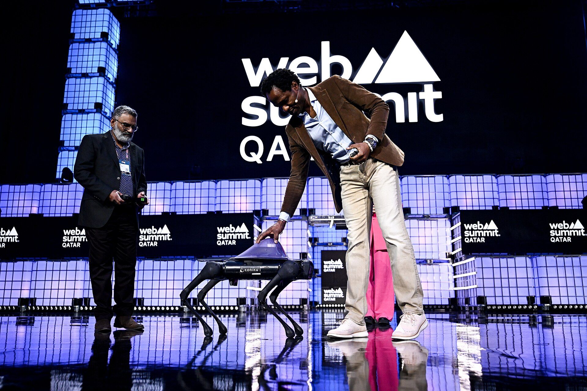 The main stage at Web Summit Qatar in Doha, lit in purple with a giant Web Summit Qatar logo
