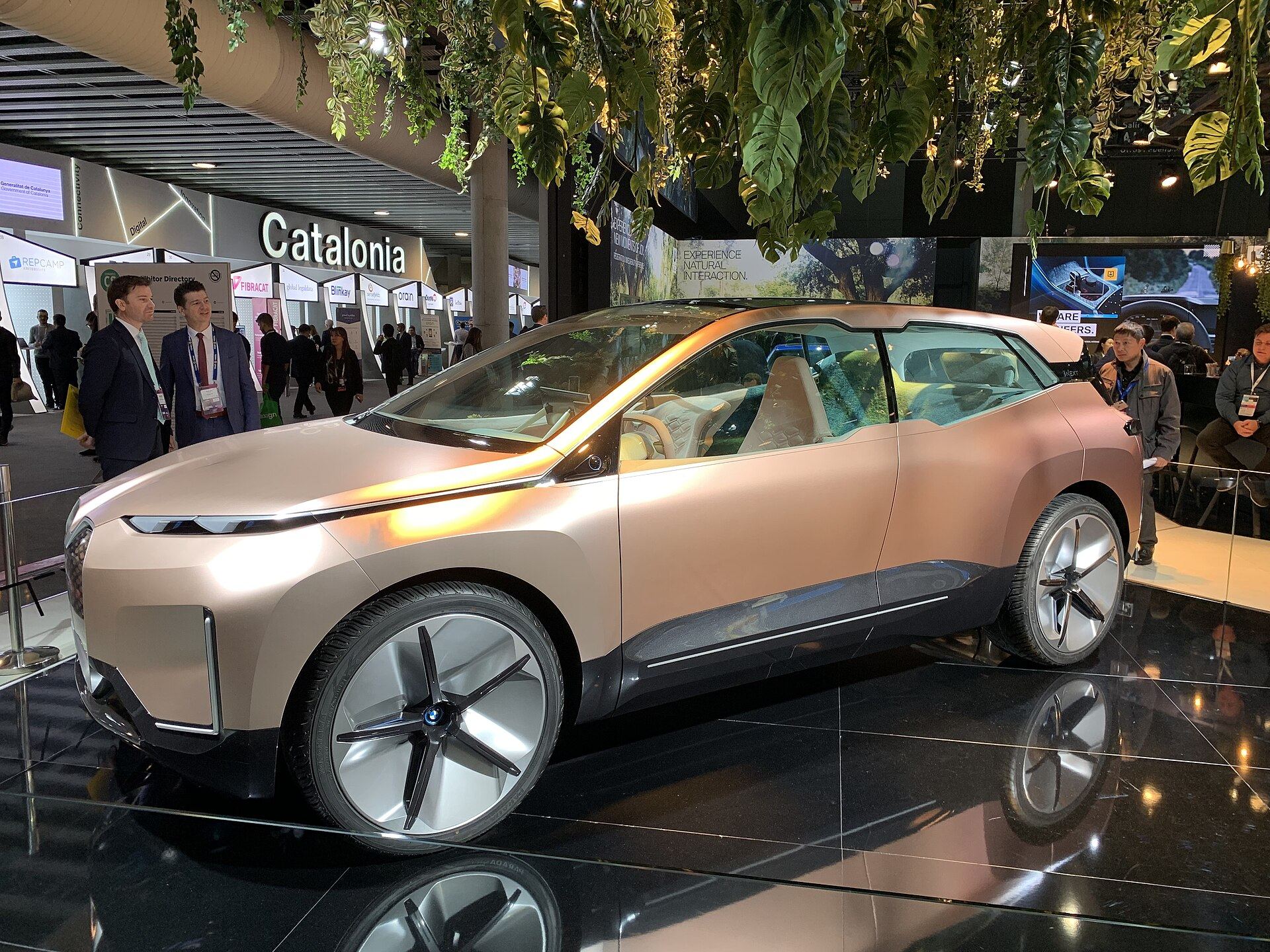 BMW's stand at MWC Barcelona, a concept car on a mirrored plinth under hanging greenery