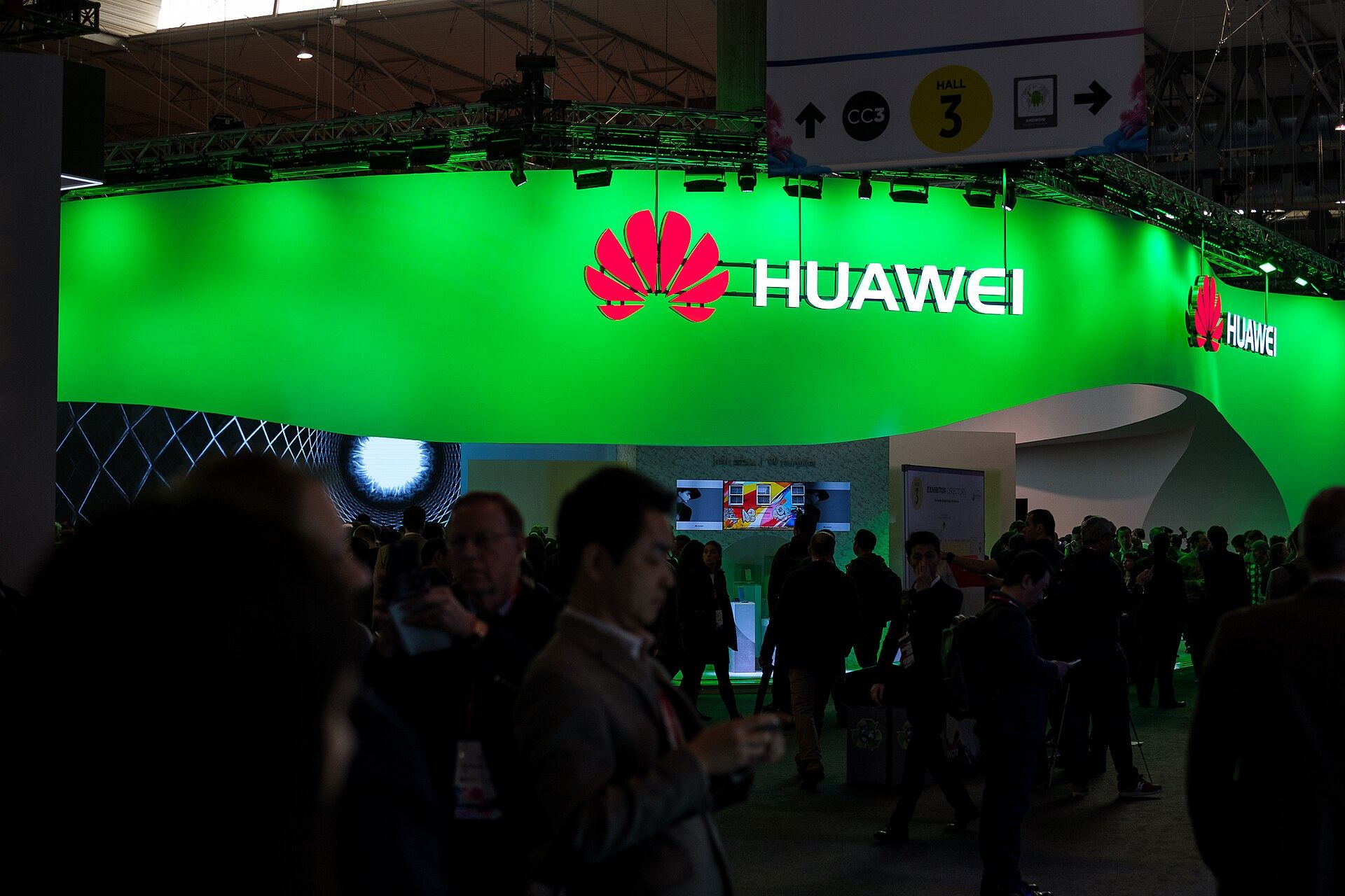 Huawei's stand at MWC Barcelona, a curved canopy glowing green above the crowd